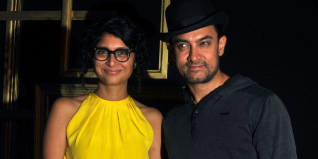 Indian Bollywood actor Aamir Khan (R) poses with his wife Kiran Rao as they arrive to attend a party hosted by actress Deepika Padukone in Mumbai late December 21, 2013. AFP PHOTO/STR (Photo credit should read STRDEL/AFP/Getty Images)