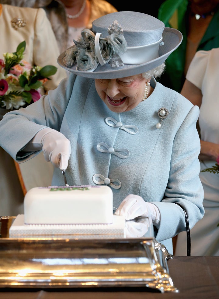 Britain's Queen Elizabeth cuts a Women's Institute Celebrating 100 Years cake at the Royal Albert Hall in London on June 4, 2015. (This is not the chocolate biscuit cake). 