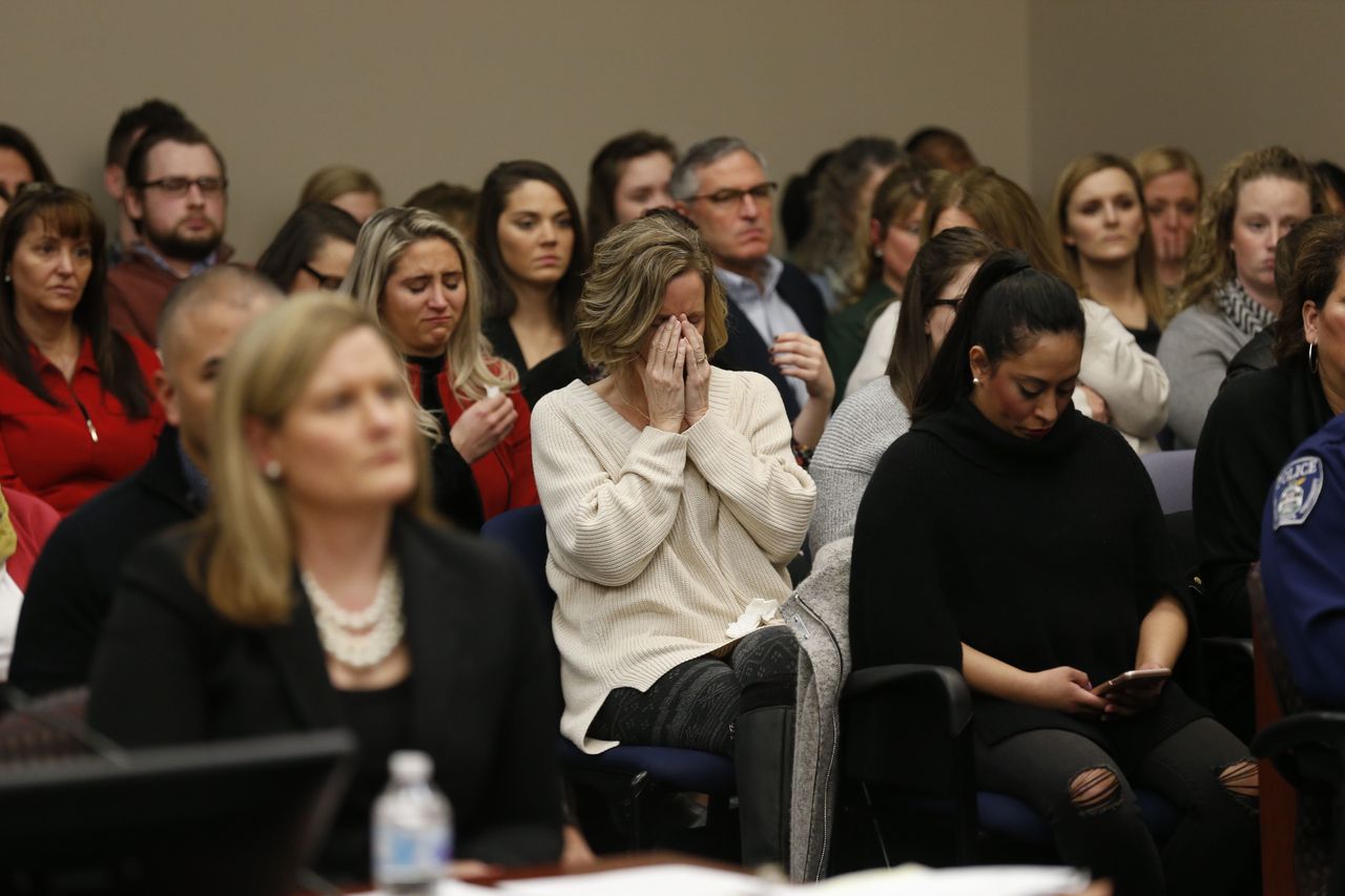 People in the courtroom react as former Michigan State University and USA Gymnastics doctor Larry Nassar listens during impact statements during the sentencing phase in Ingham County Circuit Court on January 24, 2018 in Lansing, Michigan.More than 100 women and girls accuse Nassar of a pattern of serial abuse dating back two decades, including the Olympic gold-medal winners Simone Biles, Aly Raisman, Gabby Douglas and McKayla Maroney -- who have lashed out at top sporting officials for failing to stop him. / AFP PHOTO / JEFF KOWALSKY (Photo credit should read JEFF KOWALSKY/AFP/Getty Images)