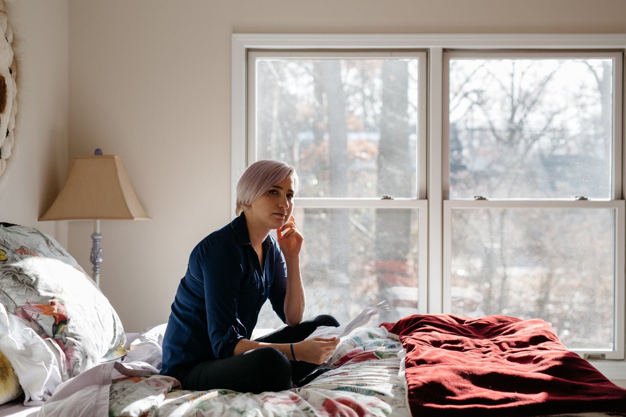 Amanda Thomashow, age 29, poses for a portrait on the bed where she originally wrote her impact statement about Larry Nassar a year ago.