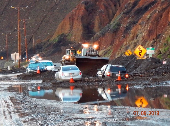 In this Sunday, Jan. 6, 2019 photo, California Department of Transportation (CalTrans) crews work to clear mud and rocks that