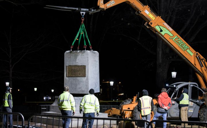 The remnants of a Confederate statue known as "Silent Sam" is lifted before being transported to the bed of a truck early Tuesday on the campus of the University of North Carolina in Chapel Hill, N.C.
