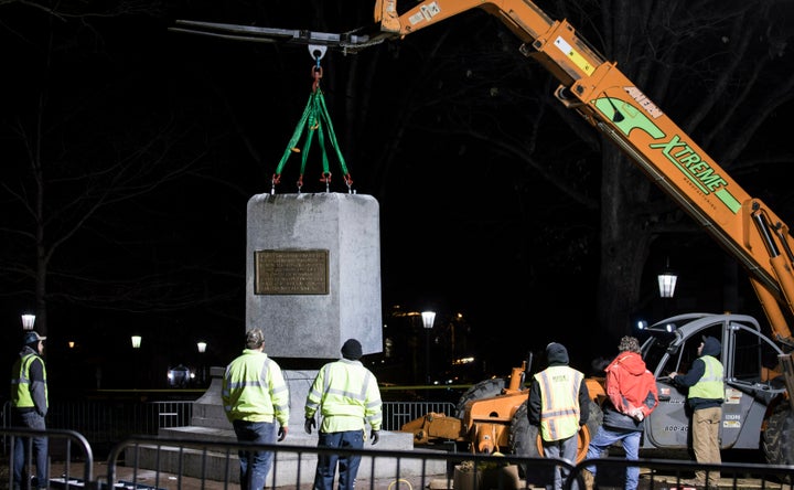 The remnants of a Confederate statue known as "Silent Sam" is lifted before being transported to the bed of a truck early Tue