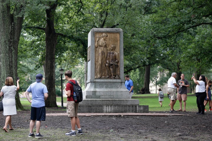 People gather around the remainder of the Silent Sam monument after it was toppled from its pedestal by protesters at the Uni