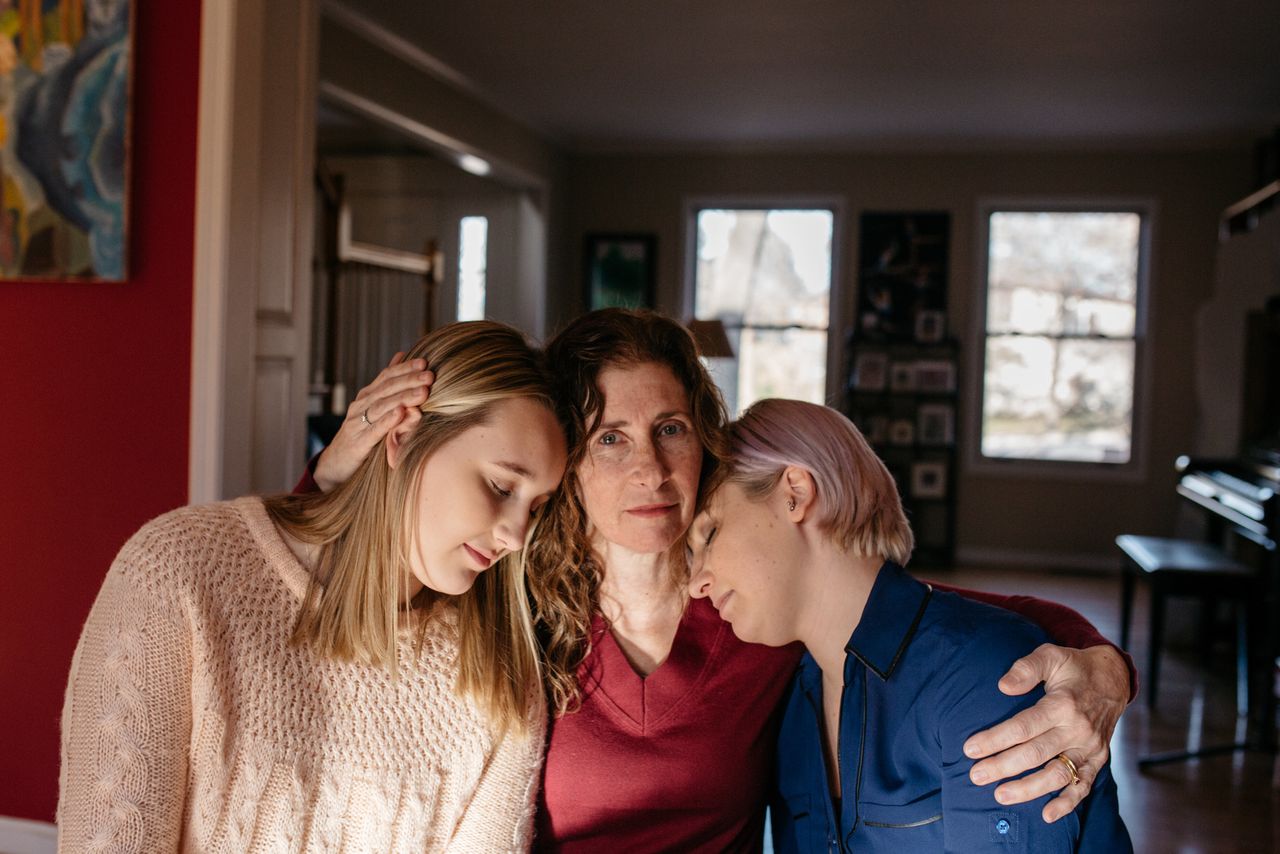 Suzanne Thomashow (center), a pediatrician and mother to Amanda (right) and Jessica (left), Nassar survivors inside their home in Lansing, Michigan.