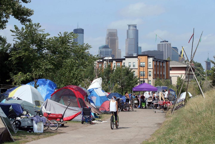 In this Sept. 14, 2018 photo, the skyline rises behind a homeless encampment in south Minneapolis.