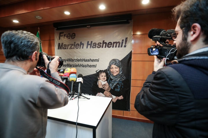 Journalists photograph and film a poster depicting Marzieh Hashemi, during a press conference by her employer Press TV in Teh