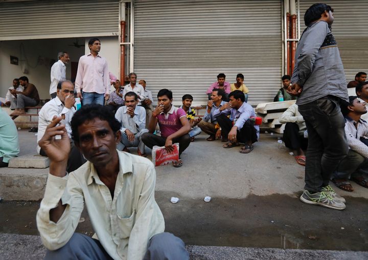 Unorganised sector workers sit on a footpath as they wait to get hired for work in Mumbai on November 6, 2017, a year after demonetisation.