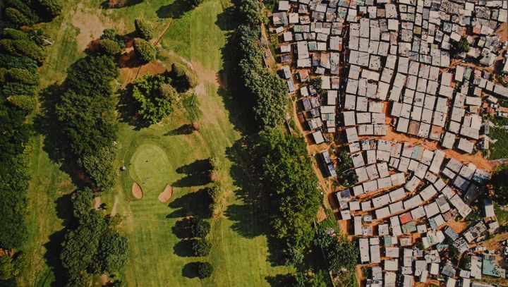 A sprawling informal settlement sits near the manicured fairways of a golf course in Durban, South Africa. The wealth of billionaires has increased by $900 billion in the last year. Meanwhile, the poorest half of the world saw its wealth decline by 11 percent.