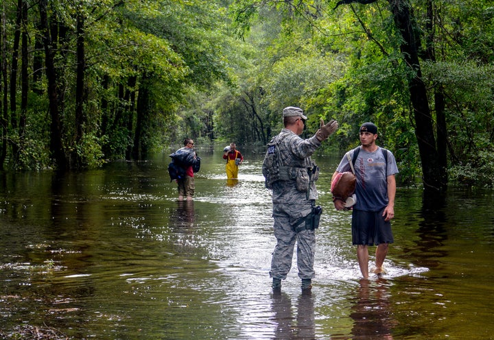 A U.S. Air Force member assigned to the South Carolina Air National Guard assists citizens during evacuation efforts after Hurricane Florence hit in September 2018.