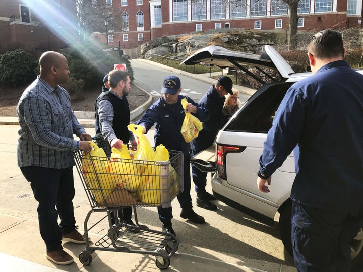 Coast Guard members volunteering at the Coast Guard Academy food pantry accept donations.