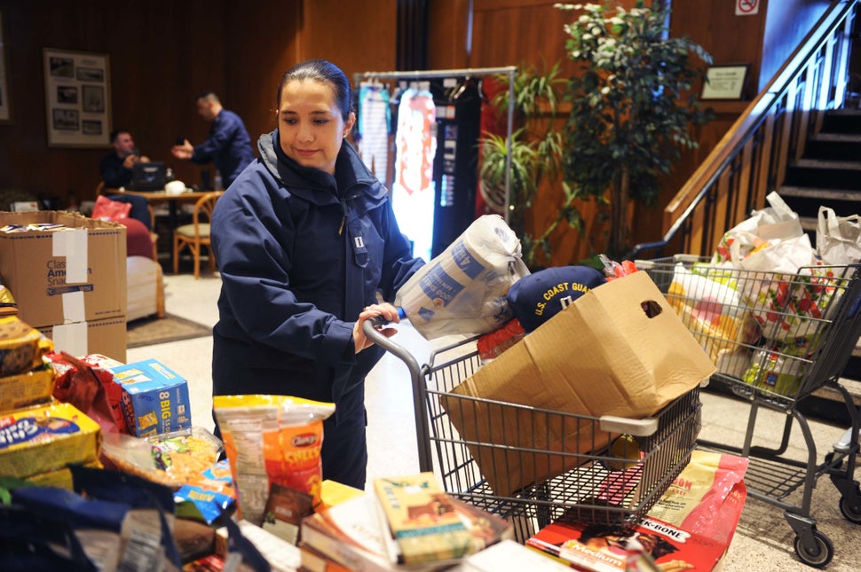 Jackie Ramirez, a Coast Guard Academy instructor, picks up donated items at a pop-up food pantry for Coast Guard members who