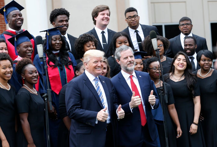 President Donald Trump with Liberty University President Jerry Falwell Jr. in front of a choir at the school's commencement ceremony in Lynchburg, Virginia, May 13, 2017. Trump delivered his first commencement address as president at Liberty.