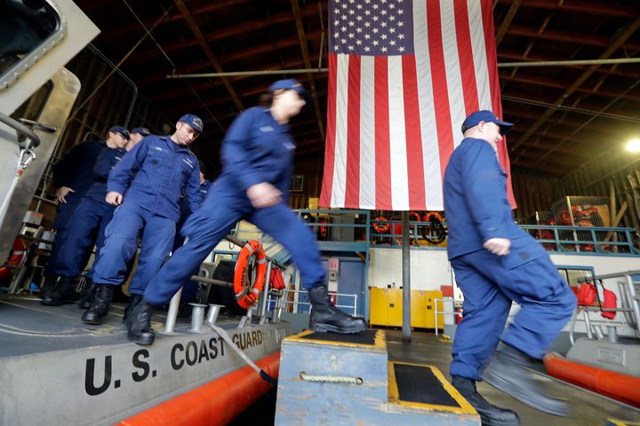 Coast Guardsmen and -women, who missed their first paycheck a day earlier because of the government shutdown, walk off a 45-foot response boat at Sector Puget Sound base in Seattle.