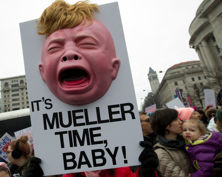 A demonstrator holds up a sign at the Women's March in Washington, D.C., reading, "It's Mueller time, baby!" including an image of a baby with Trump-like hair.