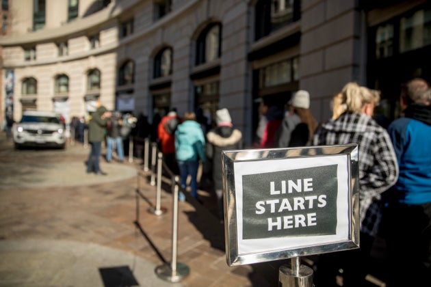 Furloughed workers wait in line on Tuesday to receive food and supplies from World Central Kitchen, the...