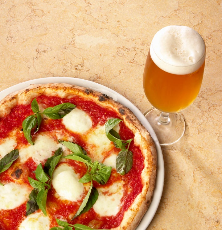 A autêntica pizza napolitana vem acompanhada de cerveja.