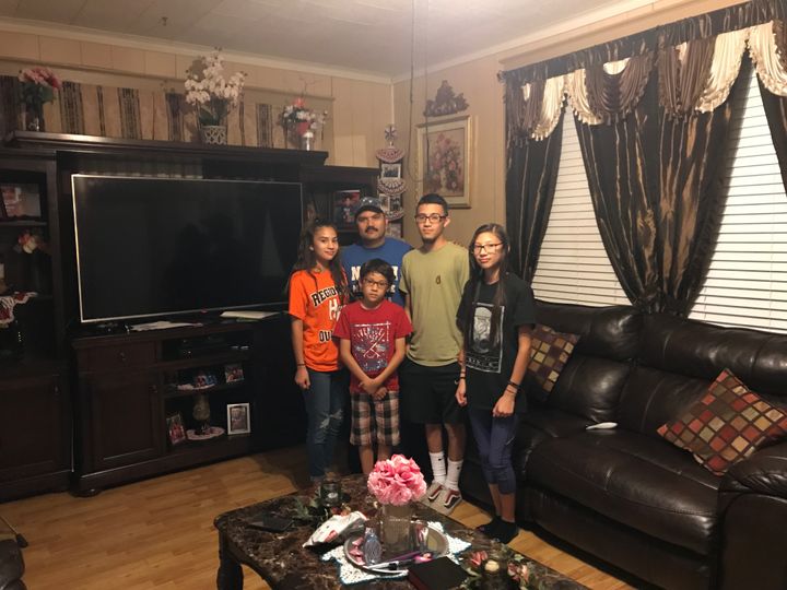 Hermenegildo Rubio stands with his children (from left) Abby, 16, Adam, 10, Danny, 20, and Noemi, 13, in the living room of his Honey Grove home. ICE raided Rubio's workplace last year, disrupting the life of his family.