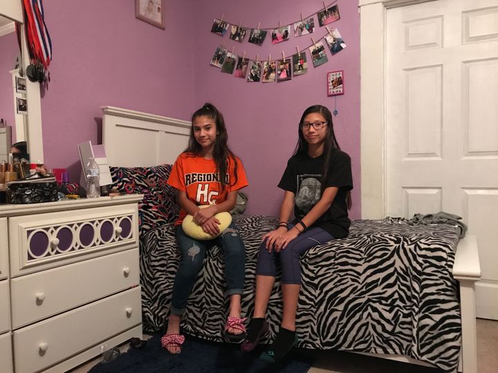 Abby Rubio, left, and her sister, Noemi, sit on Abby’s bed in their shared bedroom. 