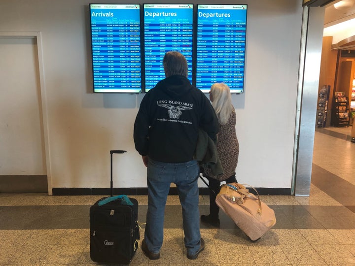 Customers check on flights at LaGuardia Airport in New York, where sweeping delays on Friday were caused by staffing issues with air traffic controllers.