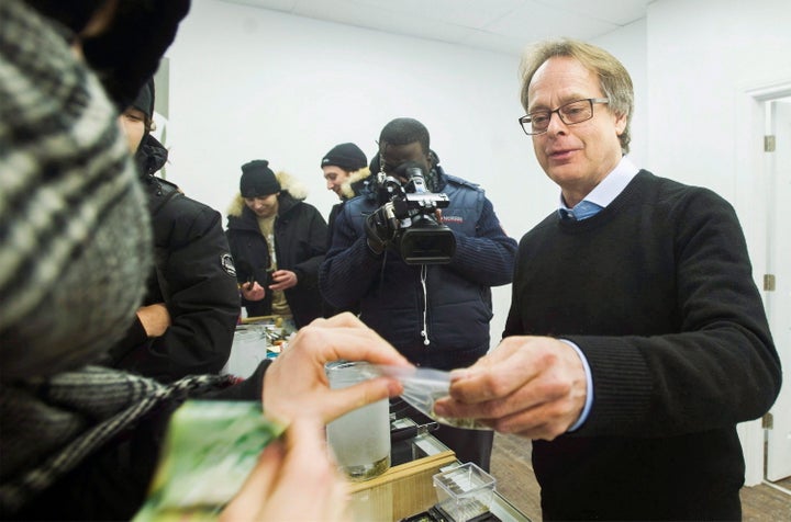 Marc Emery hands over a bag of marijuana to a customer at Cannabis Culture in Montreal on Dec. 16, 2016.