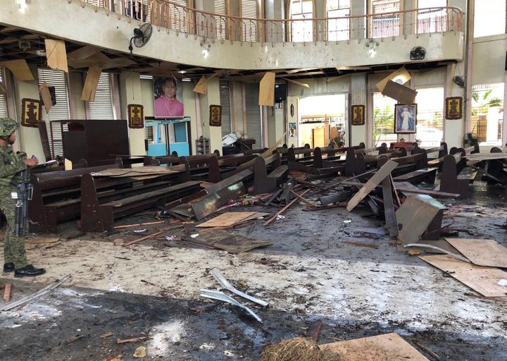 A soldier views the site inside a Roman Catholic cathedral in Jolo, the capital of Sulu province in the southern Philippines after two bombs exploded Sunday.