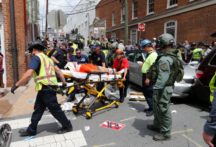 Rescue personnel help injured people after a car ran into a large group of counterprotesters at a white nationalist rally in Charlottesville, Virginia, on Aug. 12, 2017. 