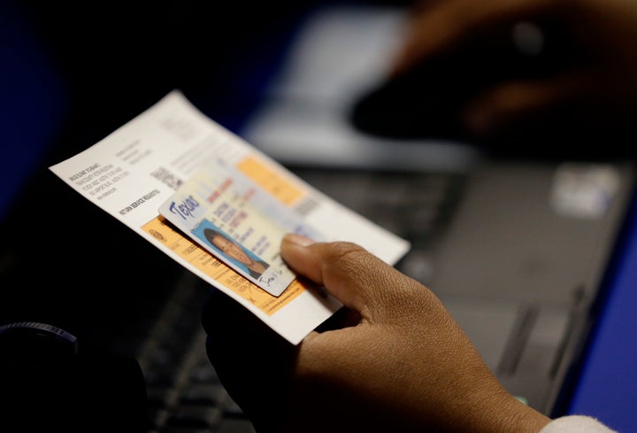 A Texas voter presents a photo ID before casting a ballot.