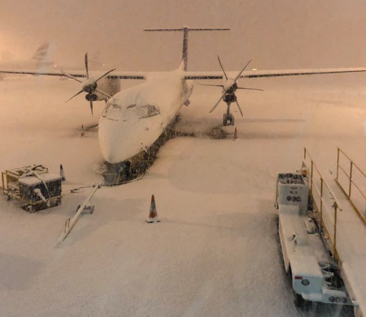 Heavy snow covered planes at Manchester Airport on Wednesday as passengers reported delays.