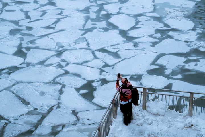 A pedestrian stops to take a photo by Chicago River, as bitter cold phenomenon called the polar vortex has descended on much of the central and eastern U.S., in Chicago, Illinois.