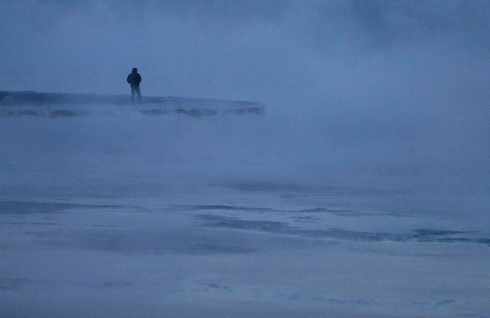A man walks along the shore of Lake Michigan, Wednesday, Jan. 30, 2019, in Chicago.