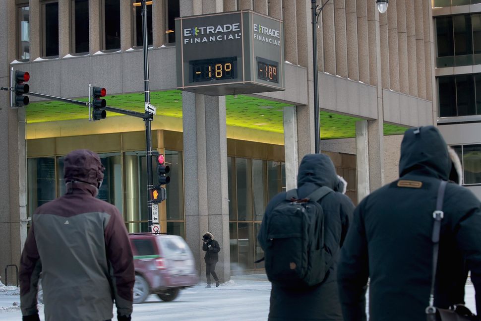 Commuters pass a thermometer registering -18 degrees downtown on Jan. 30, 2019 in Chicago.