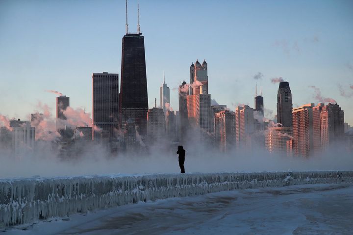 A man walks along an ice-covered break-wall along Lake Michigan in Chicago, Illinois