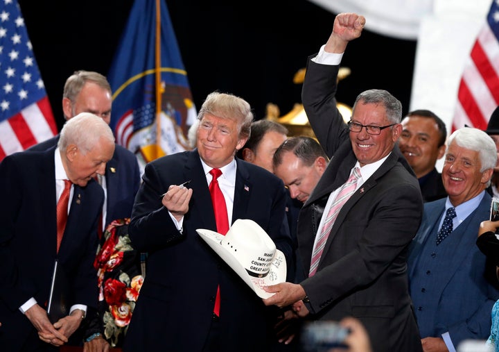 President Donald Trump signs the hat of Bruce Adams, chairman of the San Juan County Commission, after signing a proclamation to shrink the size of Bears Ears and Grand Staircase-Escalante national monuments at the Utah State Capitol in Salt Lake City.