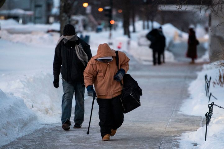 Men walk from one shelter to another in the early morning as temperatures reach -49 with wind chill in Madison, Wis. Jan. 30, 2019. 