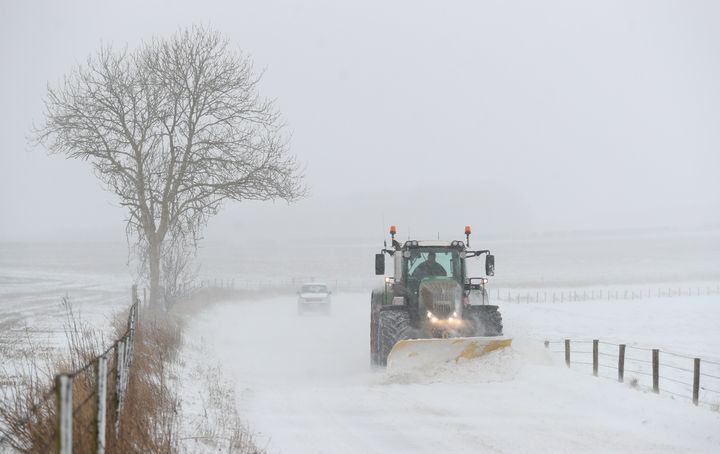 A tractor with a snowplough clears the B3081 near to Shaftesbury in Dorset on Friday.