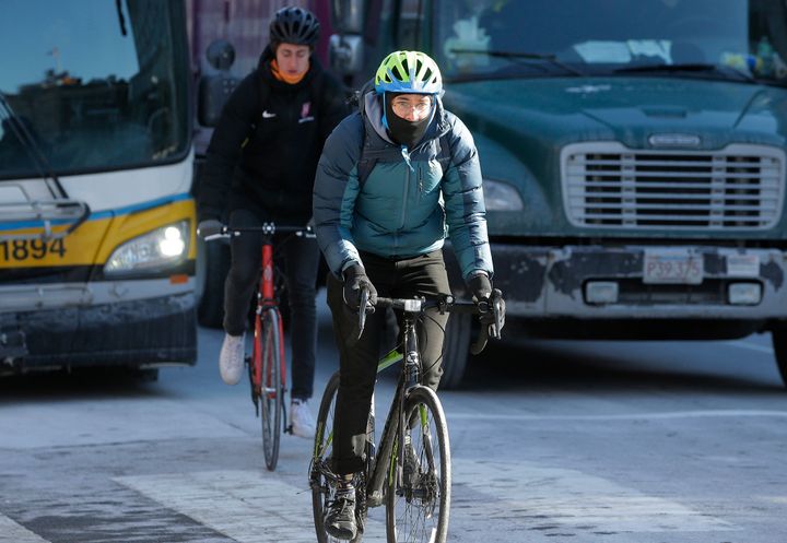 Cyclists brave freezing temperatures as they navigate traffic in Massachusetts.