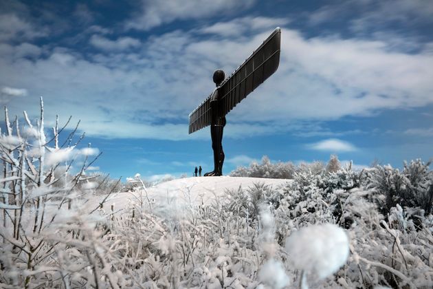 A couple stand beneath a snow-covered Angel of the North in Gateshead on Saturday.