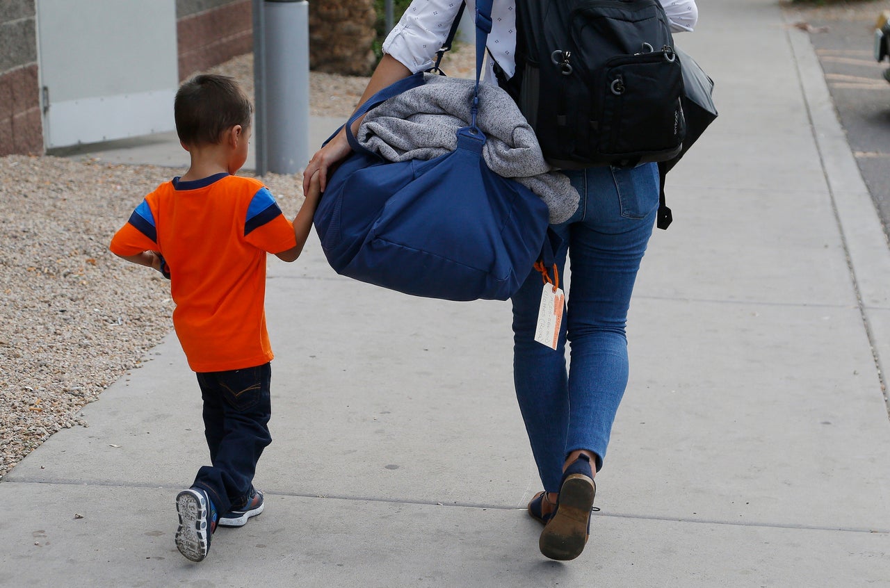 In this July 10, 2018, photo, 3-year-old Jose Jr. from Honduras is helped by a representative of the Southern Poverty Law Center as he is reunited with his father in Phoenix.