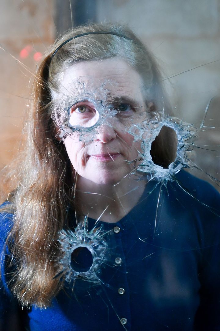 Salisbury Cathedral archivist Emily Naish looks through holes in reinforced glass that were left after a hammer attack on the casing housing an original Magna Carta inside the medieval Chapter House at the Cathedral, which is now reinstalled for the viewing public
