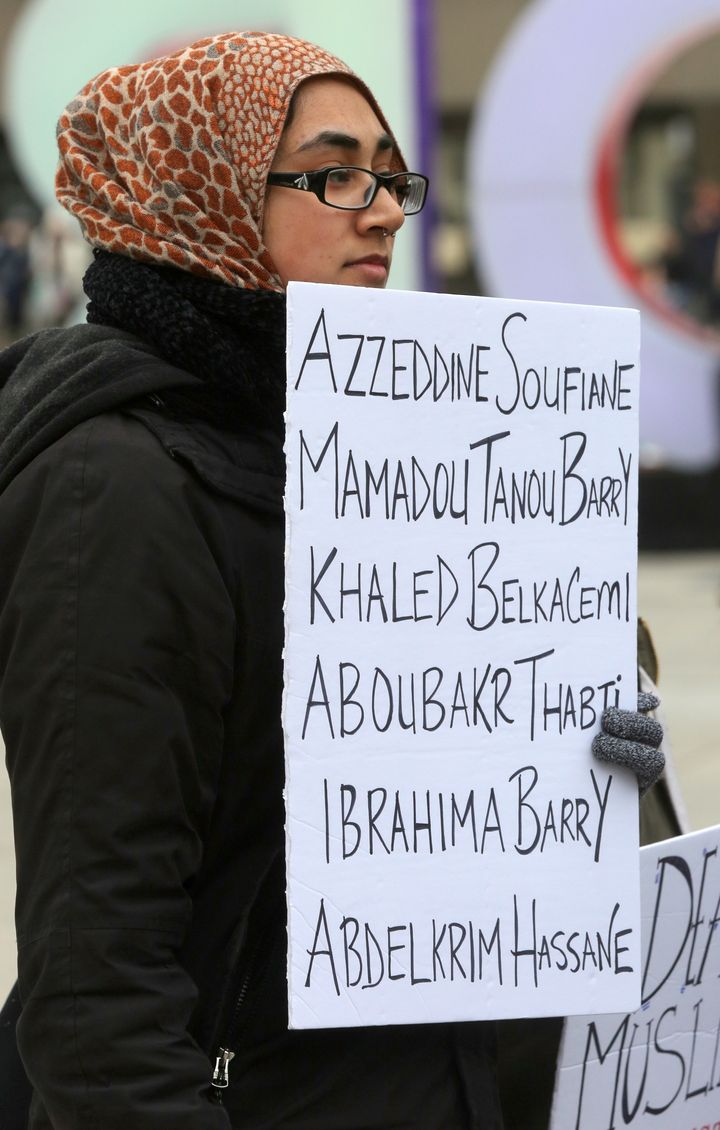During a rally held in Toronto on Jan. 27, 2018, a woman holds a sign with the names of the six people killed in the Quebec City mosque shooting a year earlier.