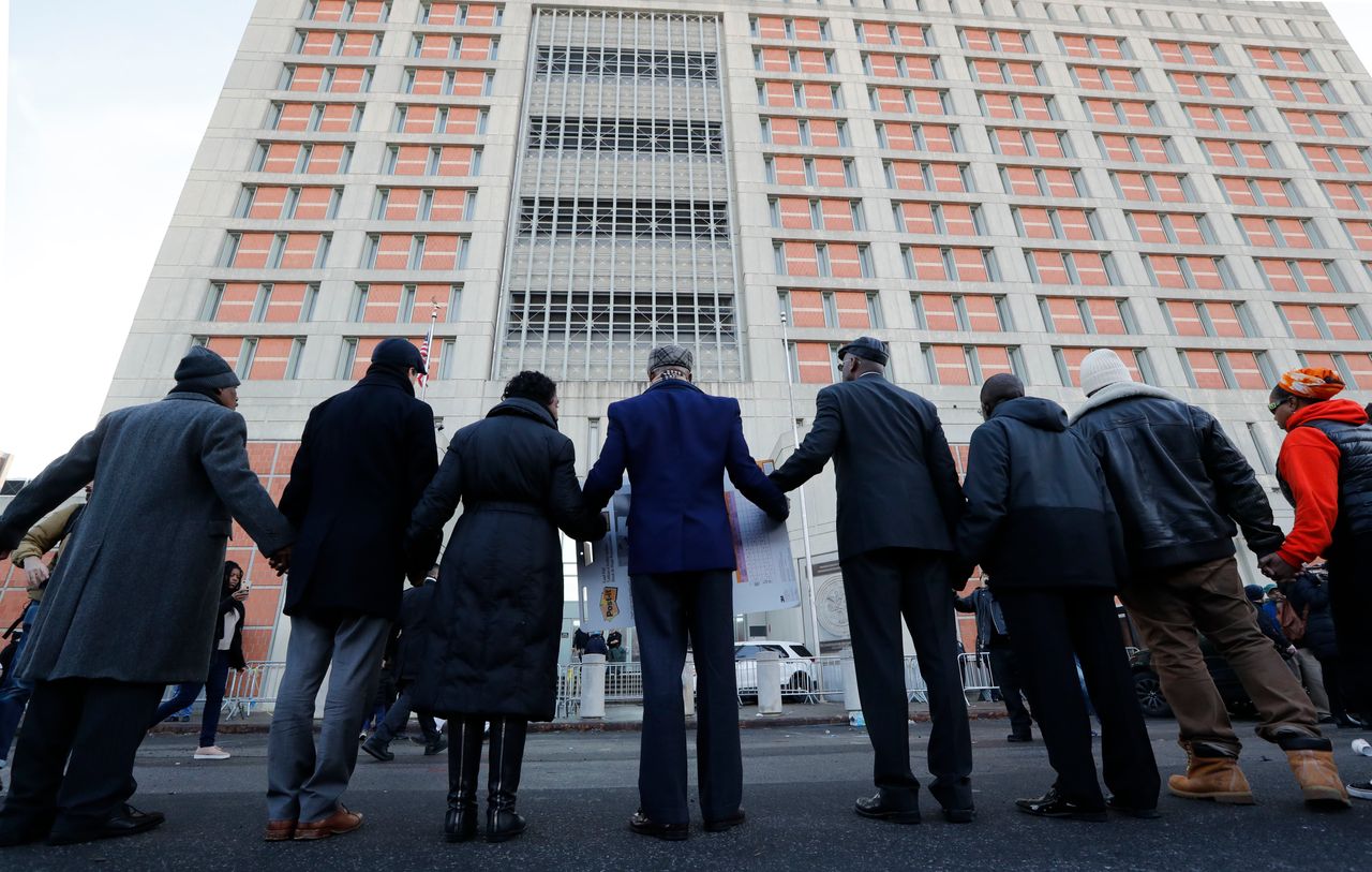 Community and religious leaders join hands to protest and pray outside the Metropolitan Detention Center, a federal prison where inmates have been without heat, hot water, electricity and flushing toilets since earlier in the week due to an electrical failure, including during the recent frigid cold snap, Sunday, Feb. 3, 2019, in New York. 