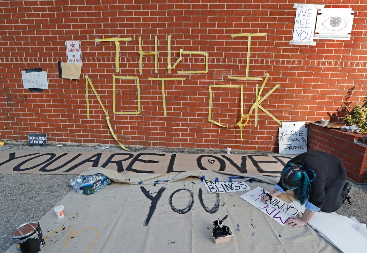 A woman makes a sign outside the Metropolitan Detention Center, a federal facility of all security levels, Sunday, Feb. 3, 2019, in the Brooklyn borough of New York. Prisoners there have been without heat, hot water, electricity and sanitation for a week.