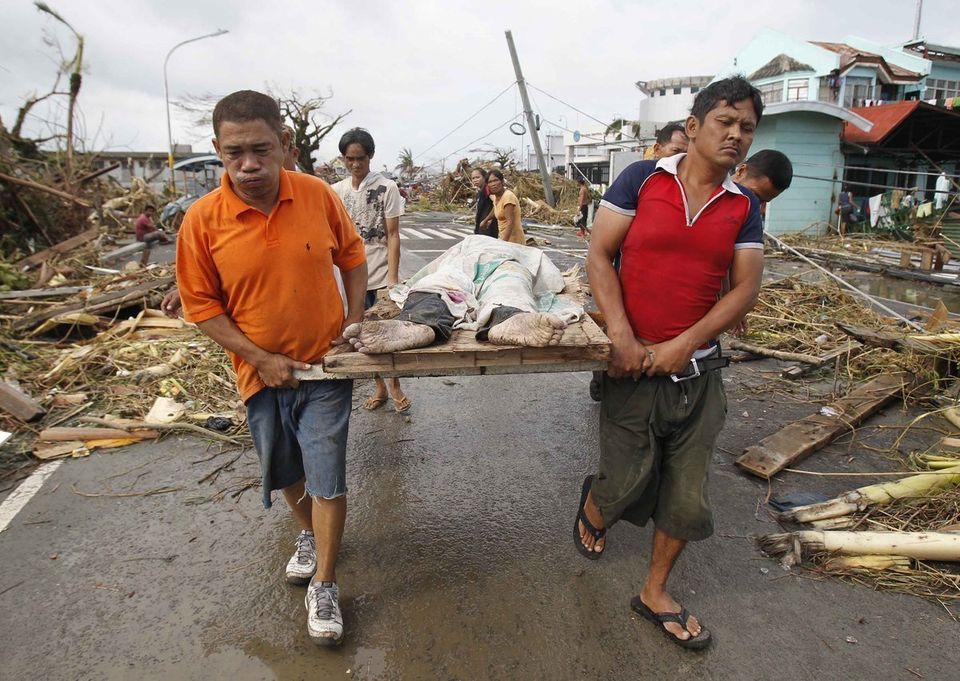 Des survivants portent un cadavre, à Tacloban 