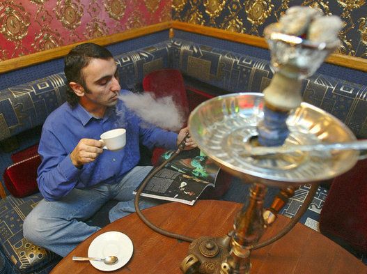 A visitor smokes a hookah in Kiev?s ?Aro