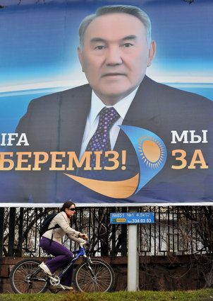 A woman cycles past an election poster o