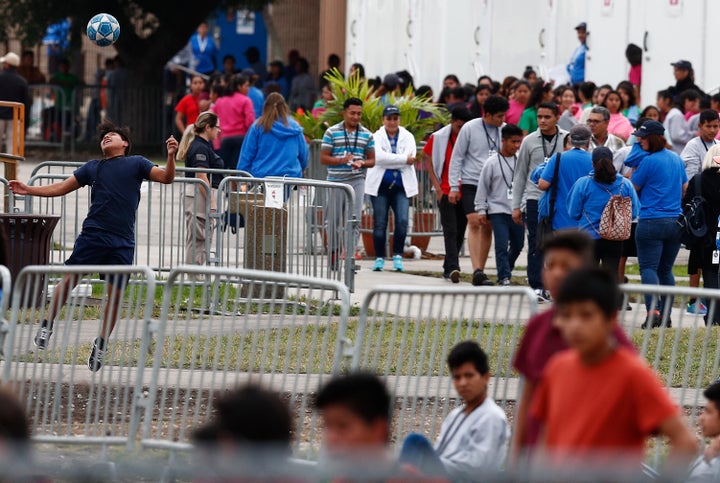 A migrant teen plays soccer as others gather at the Homestead Temporary Shelter for Unaccompanied Children in Homestead, Florida, in December.