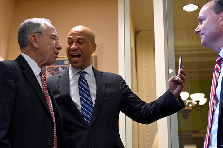 Booker cajoles Sen. Chuck Grassley (R-Iowa) to join him in an Instagram Live post in December. Looking on is Sen. Mike Lee (R-Utah).