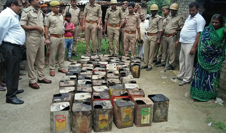 Police gather containers of bootleg alcohol recovered in a raid in Uttar Pradesh.