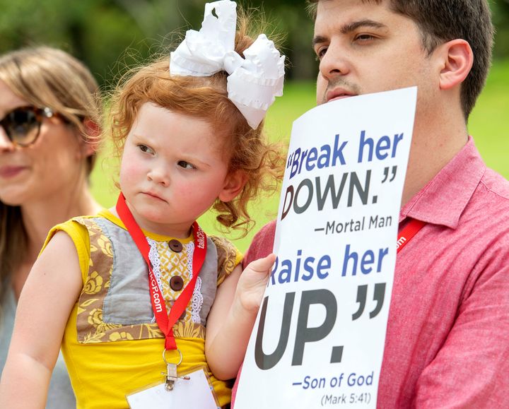 A Southern Baptist Convention member and his 2-year-old daughter attend a rally on June 12, 2018, protesting the Southern Baptist Convention's treatment of women outside the convention's annual meeting at the Kay Bailey Hutchison Convention Center in Dallas.